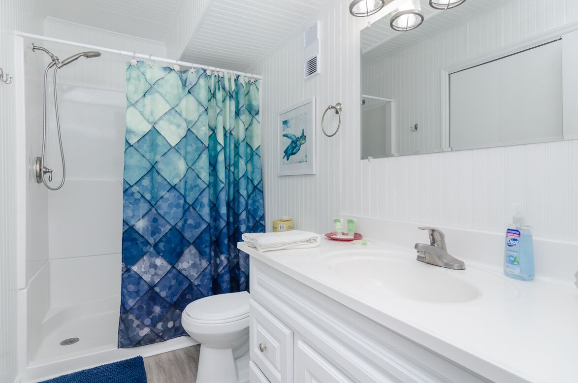 A bathroom with a shower, toilet, and sink.