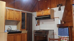 A kitchen with wooden cabinets, a stove, and a ceiling fan.
