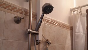A shower with a handheld showerhead, a handheld shower attachment, and a wall-mounted control valve.