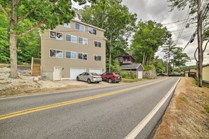 A two-story building with a garage, parked cars, and a road with double yellow lines. - Lakefront Alton Bay Retreat w/ Dock Near Beaches! (Alton Bay)