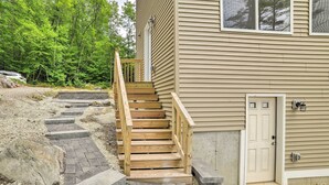 A wooden staircase leading to a house with a beige exterior. - Lakefront Alton Bay Retreat w/ Dock Near Beaches! (Alton Bay)