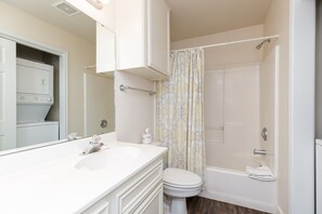 Een bad/douchecombinatie, een haardroger, handdoeken, shampoo