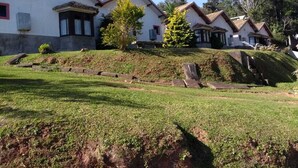 A row of white buildings with brown roofs, arranged on a hillside. - Pousada Por do Sol (Camanducaia)