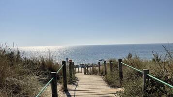 A wooden boardwalk leading to the beach with a clear view of the ocean.
