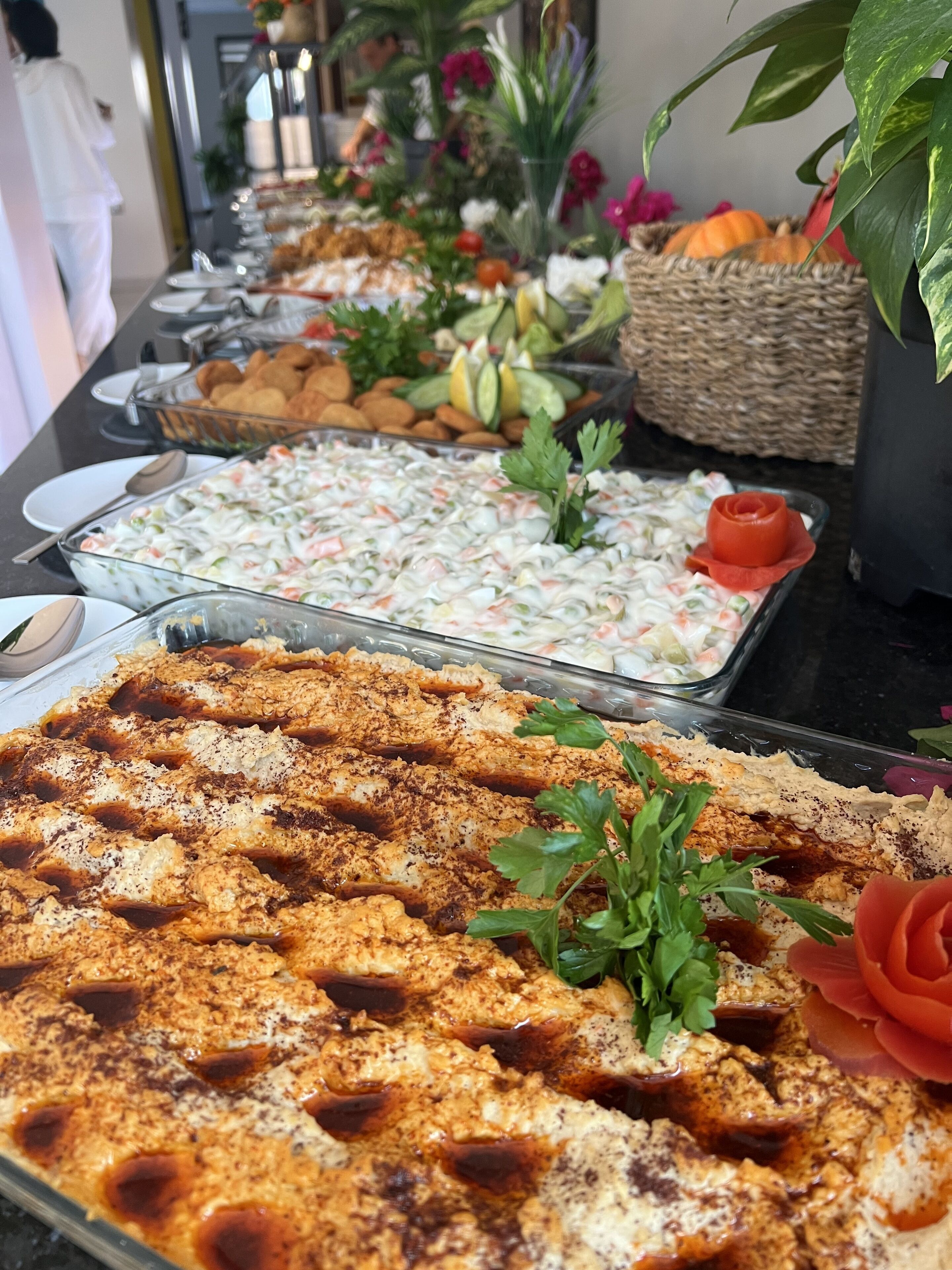 Ein Buffet mit verschiedenen Speisen, darunter eine große Platte paniertes Hähnchen, Salat und weitere Gerichte.