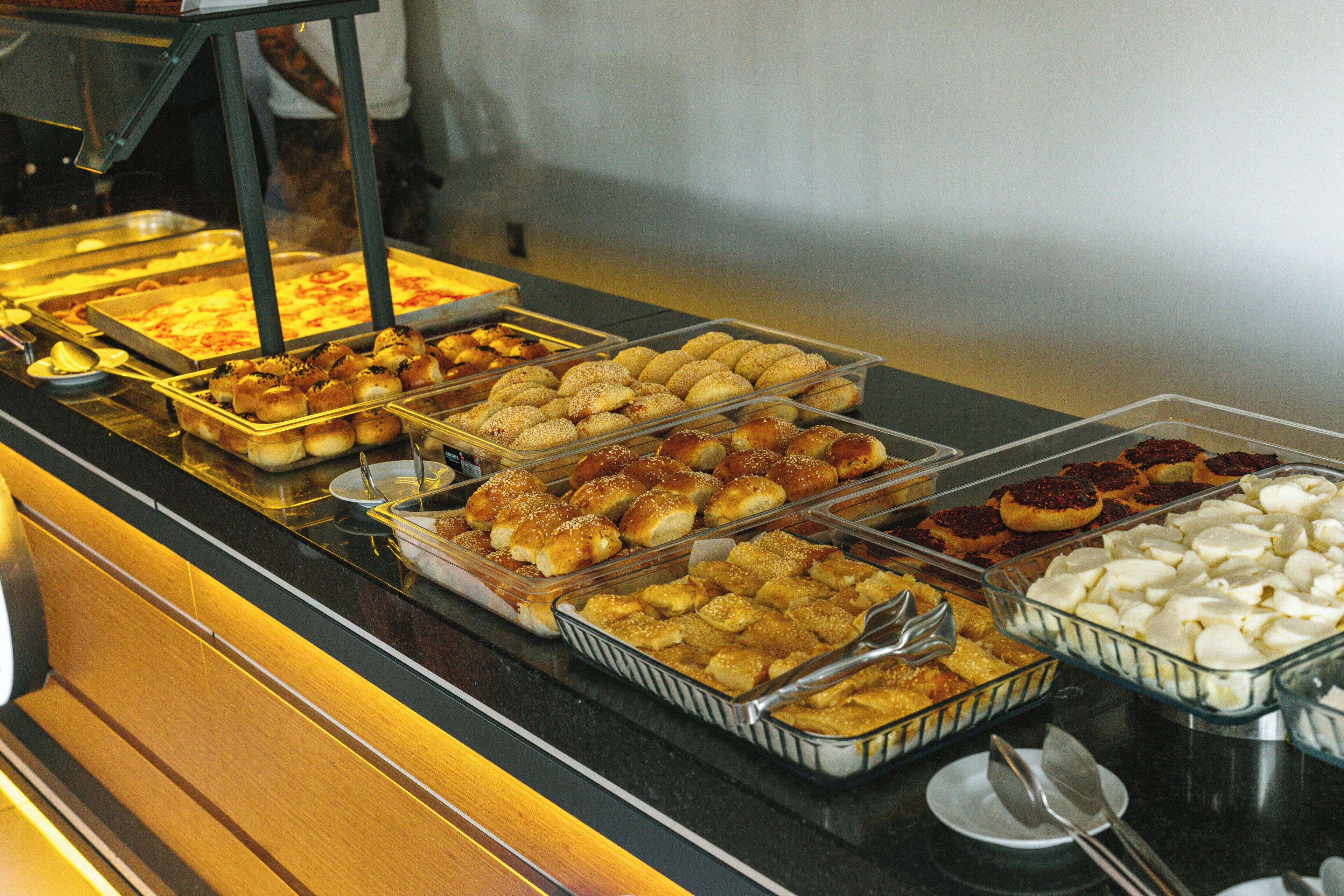 Un bufé con diversos productos de panadería y postres.
