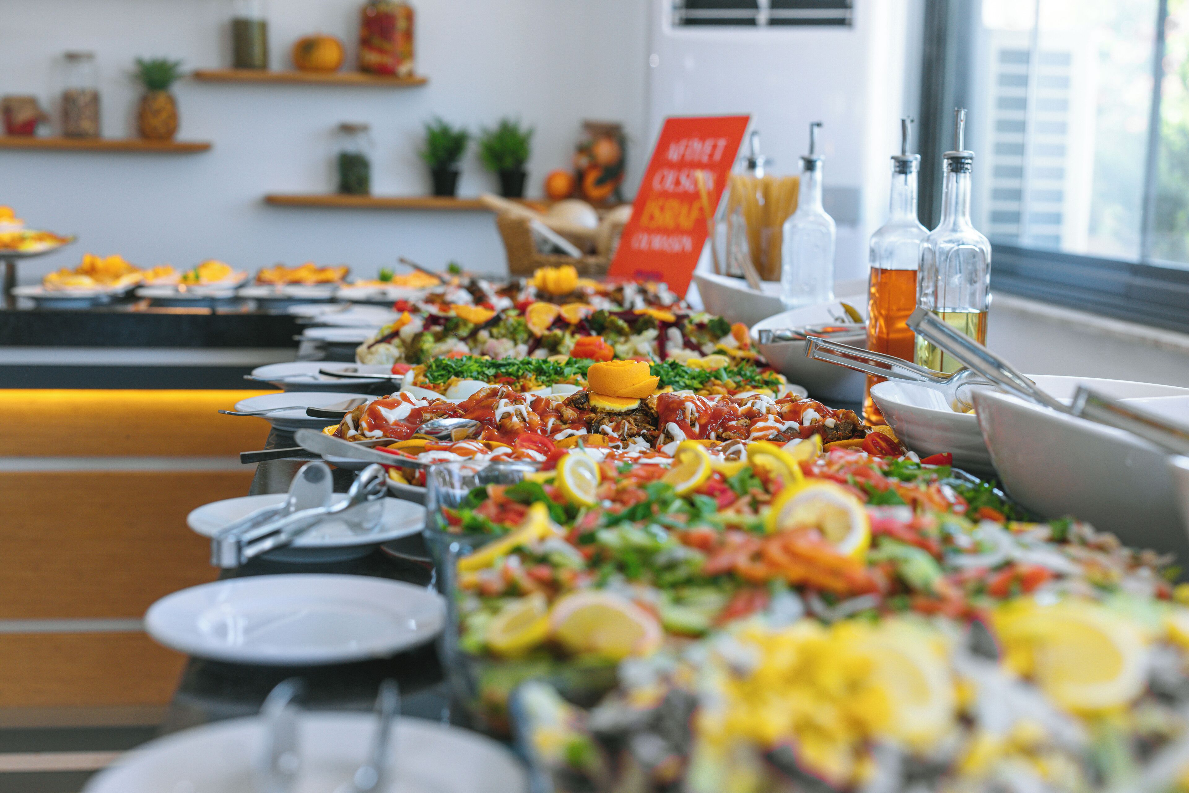 A buffet with various dishes and condiments.