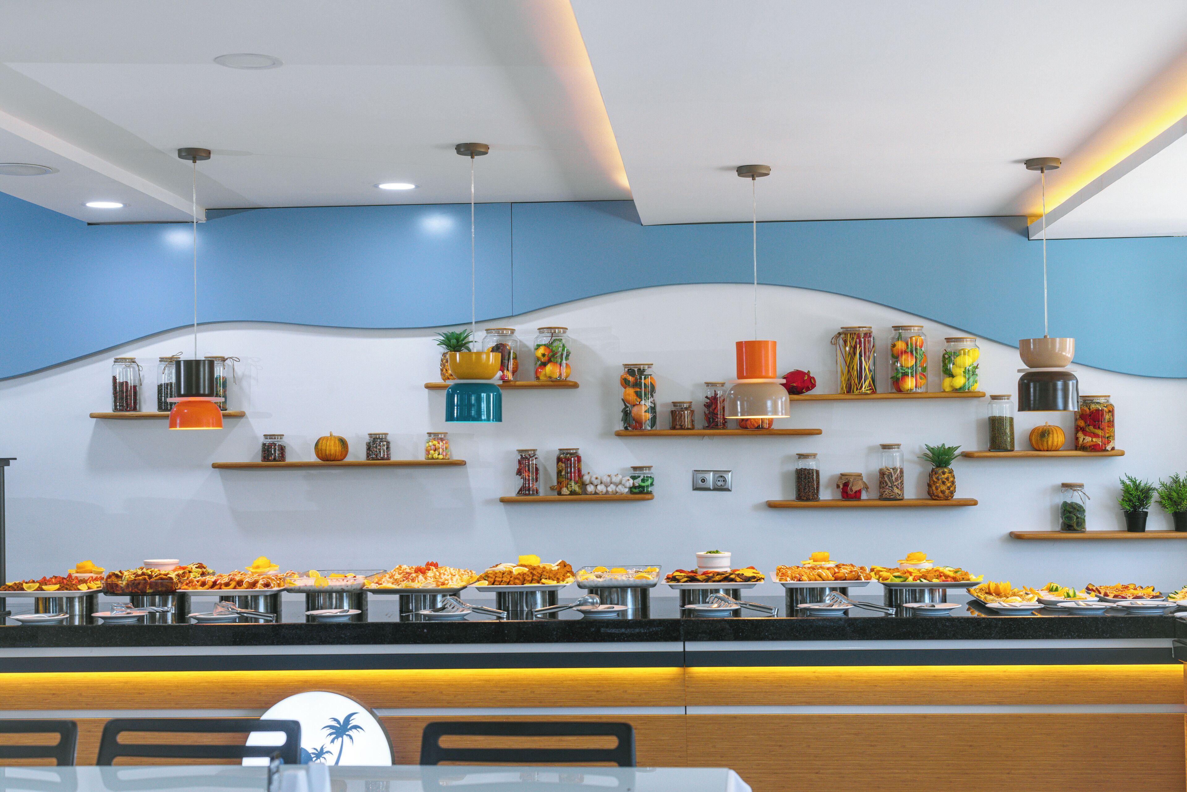 A buffet area with various food items and shelves with jars and plants.