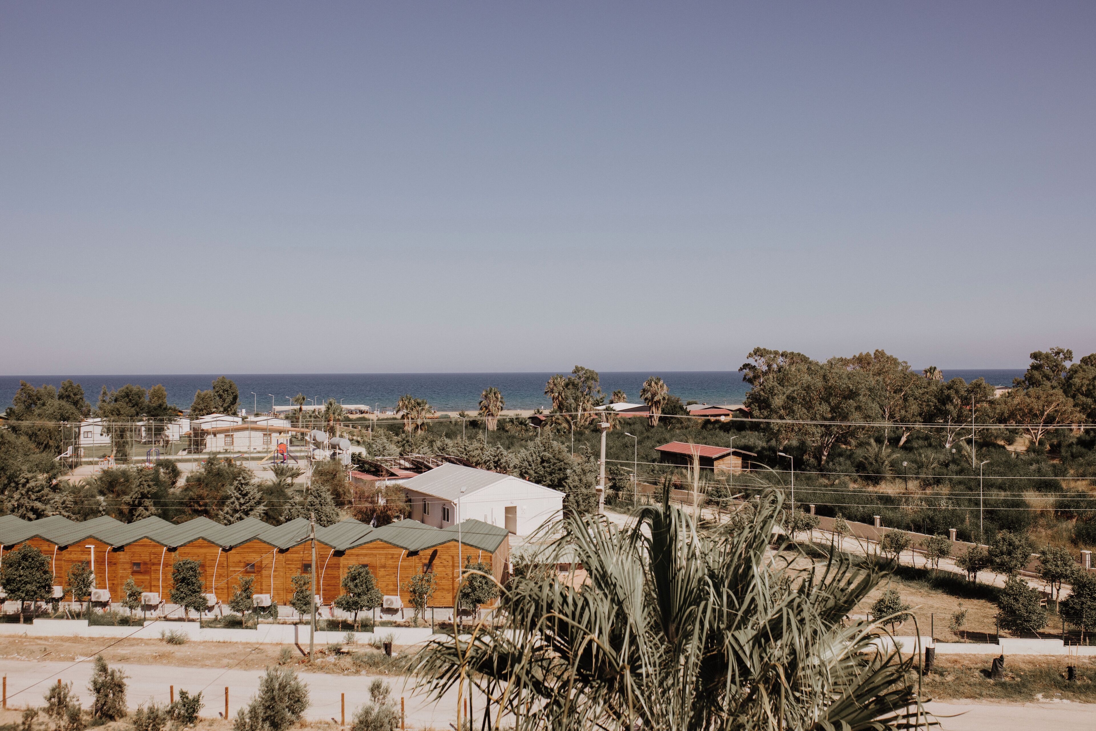 A coastal residential area with wooden cabins and a view of the sea.