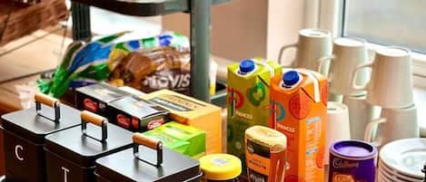 A breakfast buffet with various food items, condiments, and a selection of beverages.
