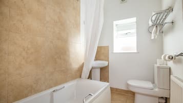 A bathroom with a bathtub, toilet, and sink.