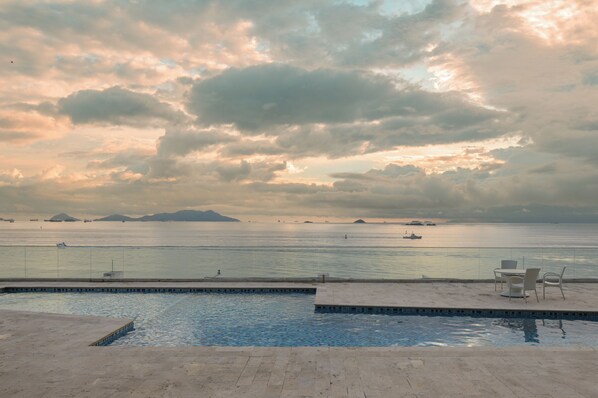 Un espace piscine offrant une vue sur la mer et les îles lointaines.