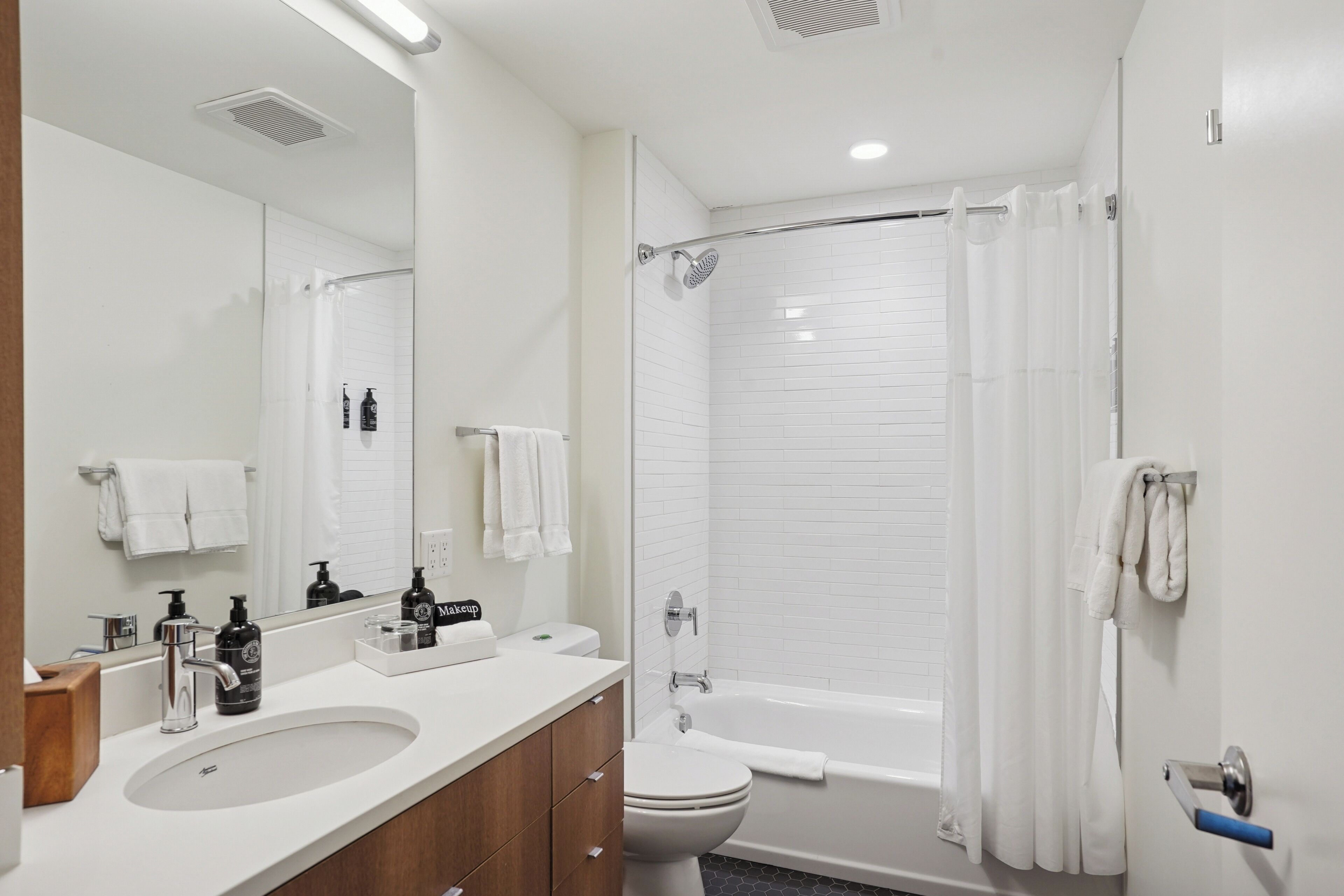 A modern bathroom with a sink, toilet, and shower.
