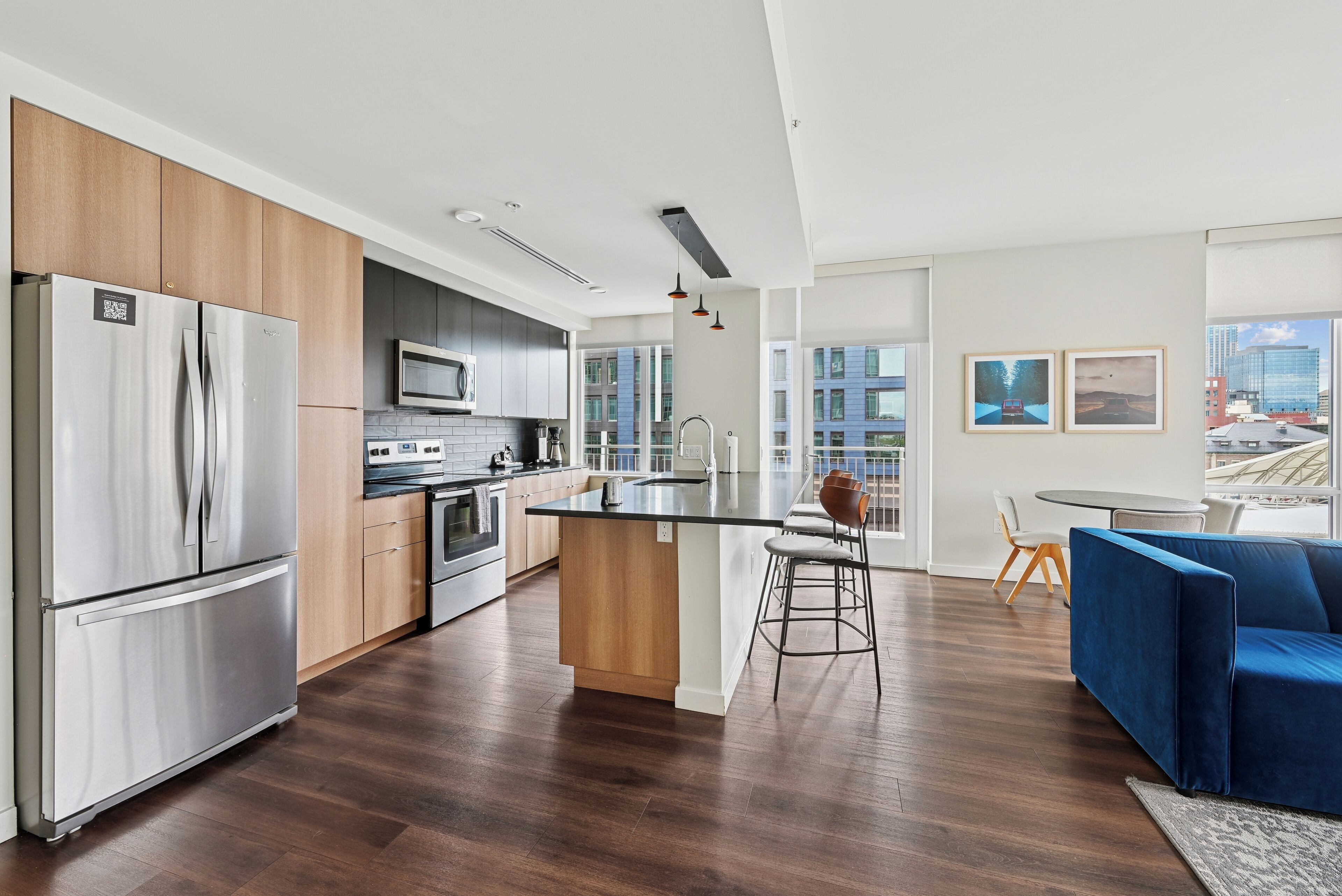 A modern kitchen with a central island, stainless steel appliances, and a view of the city.
