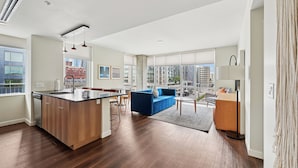 A modern apartment with a kitchen, living area, and large windows offering city views. - Sentral Union Station (Denver)