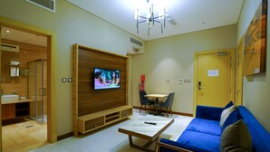 Un soggiorno moderno con televisore, divano, tavolino da caffè e zona pranzo.