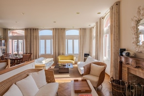 Relax in this elegantly furnished living area with a comfortable sofa set, armchair, and additional seating options.