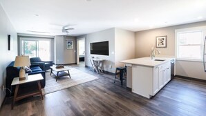 A modern apartment with a living room, kitchen, and dining area. - Long Beach Suites: 3 Mins Toes To Sand! (Gloucester)