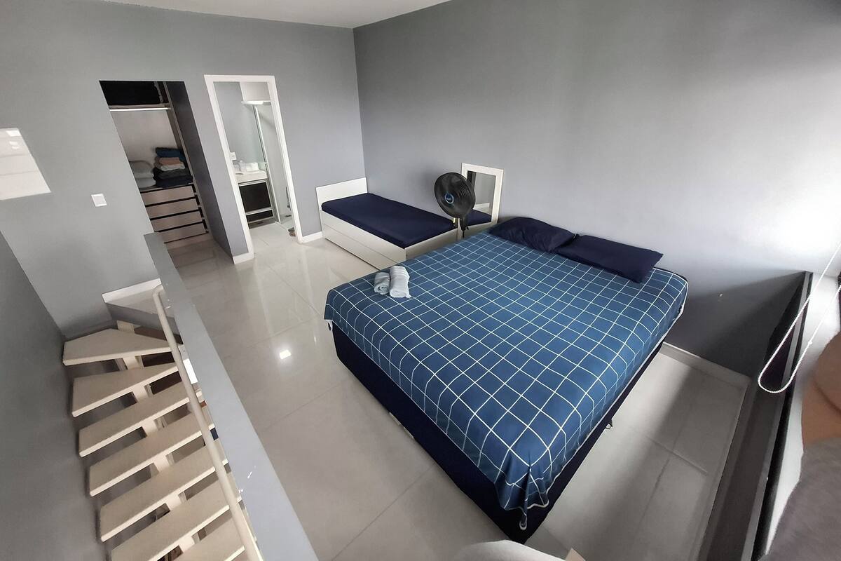 Une chambre à coucher moderne avec un lit, une table de chevet et un miroir.