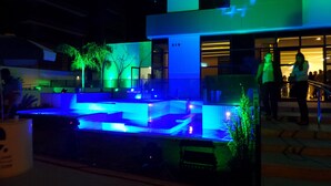 A modern building with a pool area, outdoor seating, and a staircase leading to an upper level. - Edificio Selenita Loft e Duplex (Barueri)