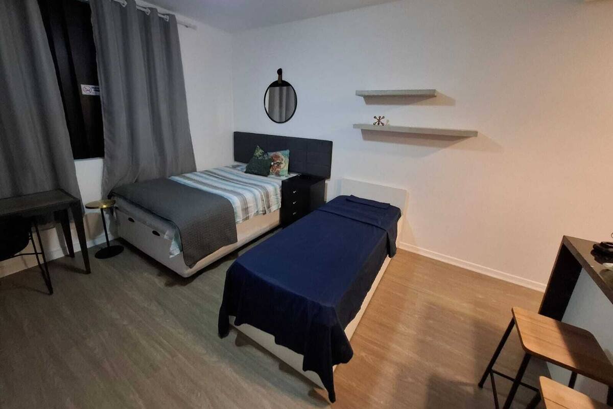 Une chambre à coucher avec un lit, une table de chevet et un bureau.