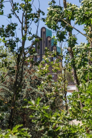 A building with a distinctive architectural style, surrounded by dense foliage. - Livingroom Mathildenhöhe (Darmstadt)