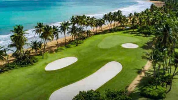 A golf course with sand bunkers and palm trees, overlooking a beach and ocean. - Lovely 2 Bed room villa in luxury resort with Beach & Pool access *golf cart (Río Grande)