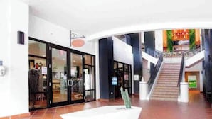 A spacious indoor area with a staircase leading to an upper level, a white wall with a door, and a tiled floor. - Lovely 2 Bed room villa in luxury resort with Beach & Pool access *golf cart (Río Grande)