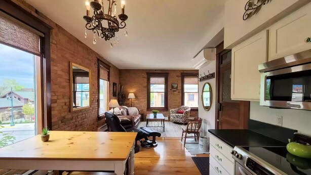 A kitchen with a built-in microwave, a stove, and a large window. - Charming and Beautiful Downtown Whitefish Condo in Historic Building (Whitefish)