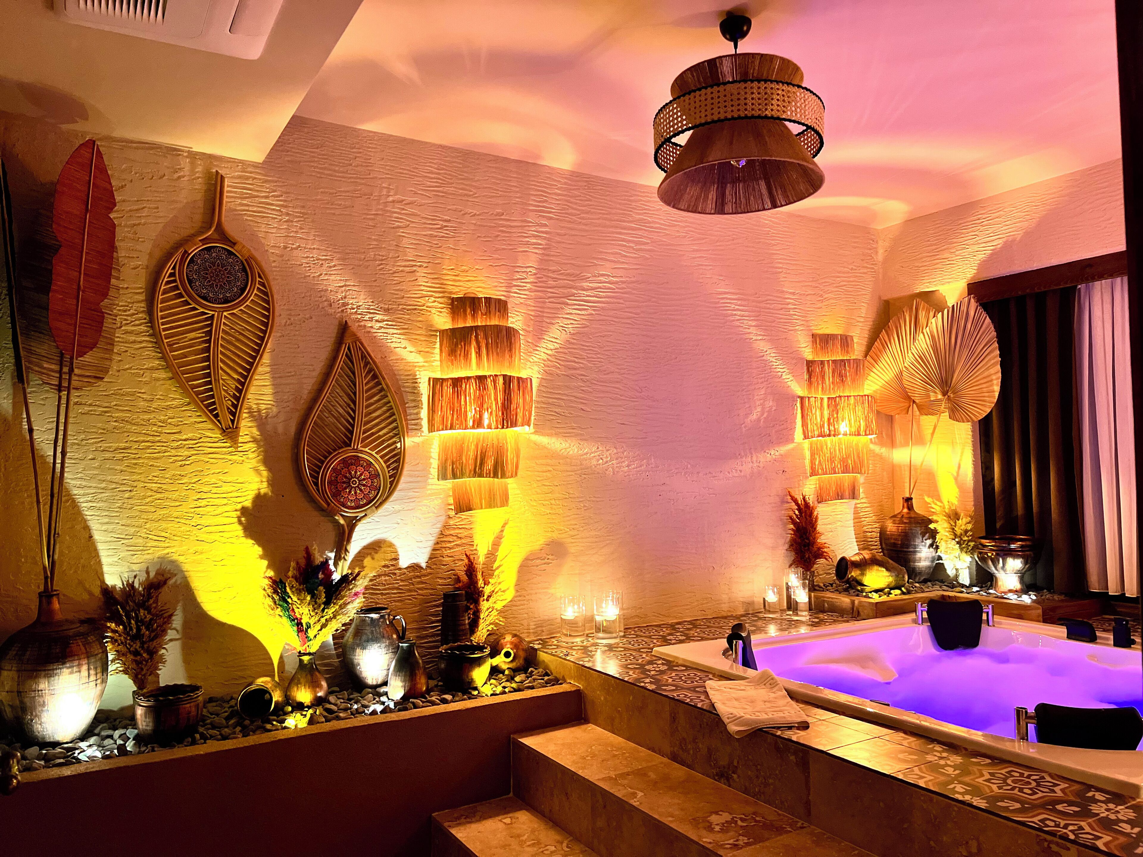 A spa area with a hot tub, decorative wall panels, and a ceiling fan.