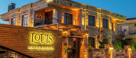 Un edificio de piedra con un letrero que dice 'LOUIS' y 'capadocia'.