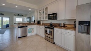 A spacious kitchen with white cabinets, stainless steel appliances, and a granite countertop.