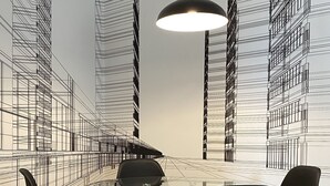 Ein Essbereich mit einem Glastisch, umgeben von Stühlen, einer hängenden Pendelleuchte und einer Wand mit einer schwarz-weißen architektonischen Zeichnung.