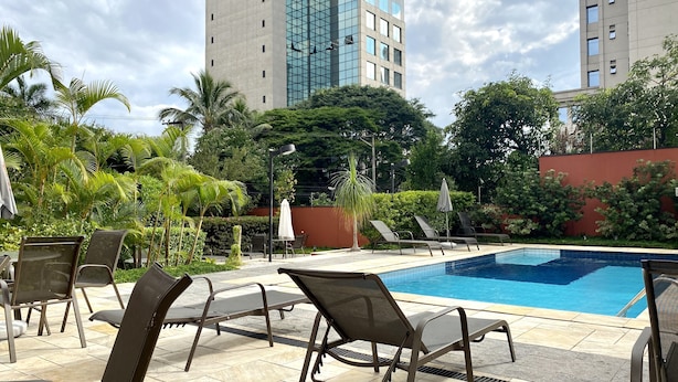 Ein Pool mit Liegestühlen und Palmen.