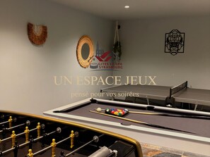 Une pièce équipée d’un baby-foot, d’une table de billard et d’une table de snooker.