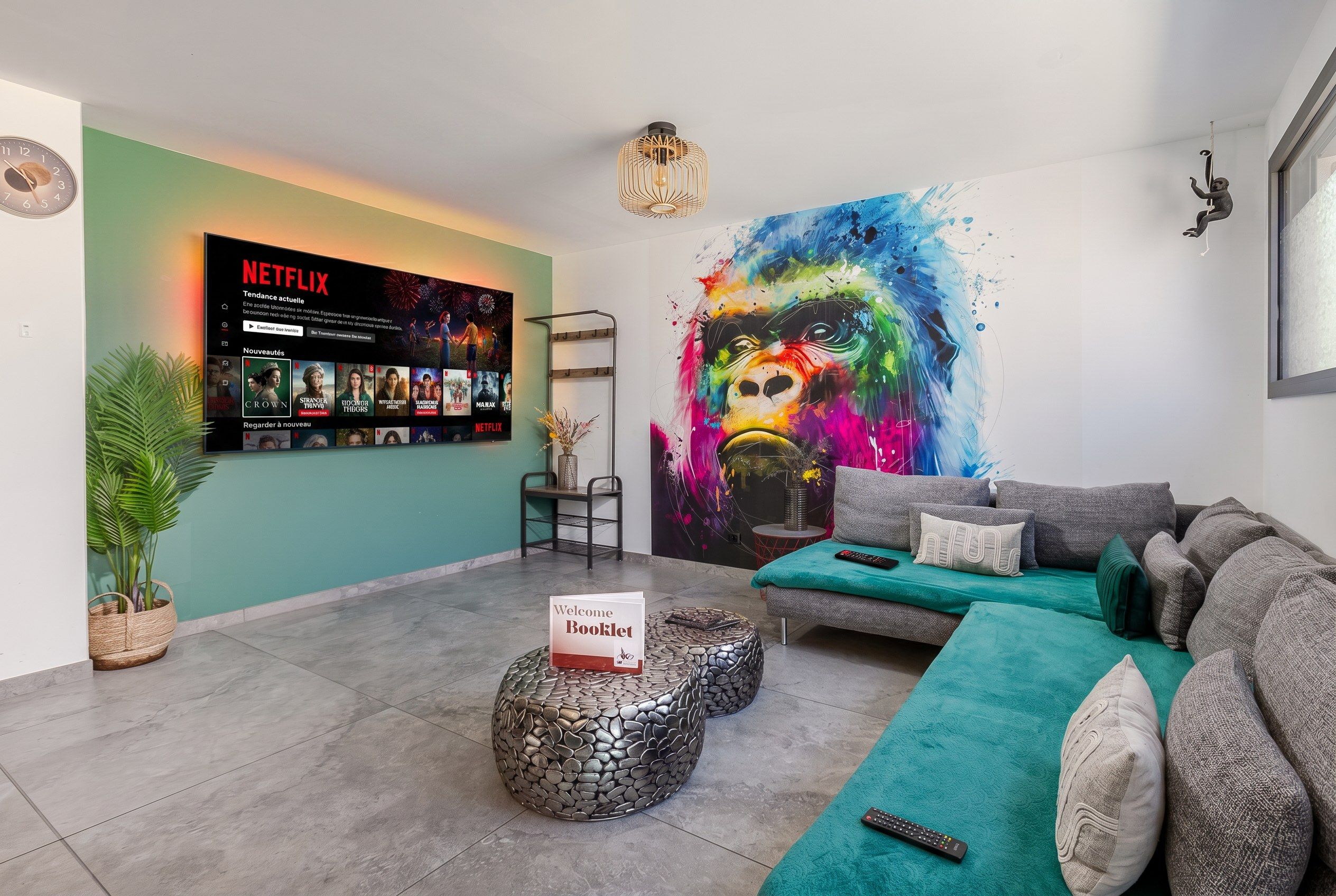 Una sala de estar moderna con una presentación de Netflix, un cuadro abstracto colorido y una zona de estar acogedora.