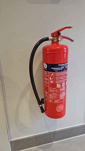 Ein roter Feuerlöscher an der Wand befestigt.