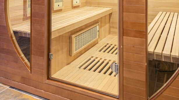 Una sauna con paredes de madera y un banco.