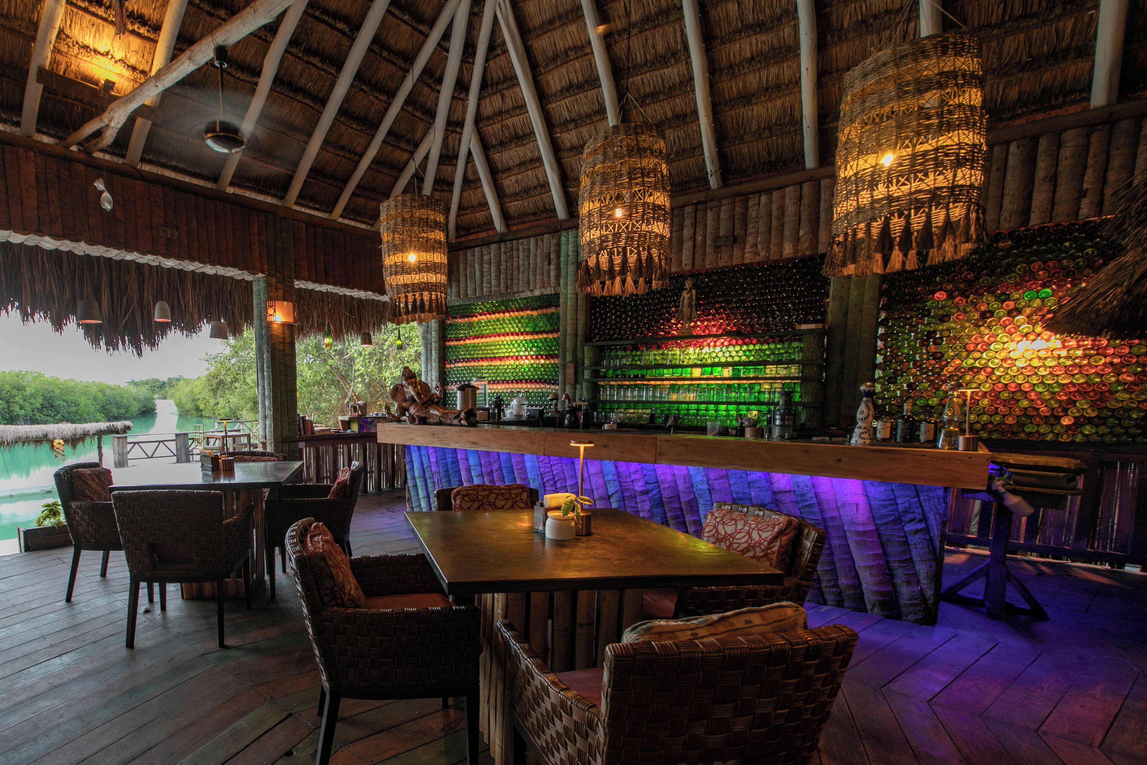 An outdoor bar area with wicker furniture and a view of a body of water.