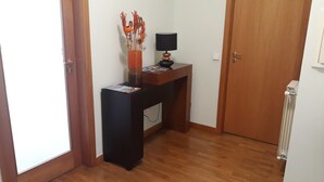 A small room with a wooden desk, a lamp, and a decorative vase. - Guida's place apartment (Porto)