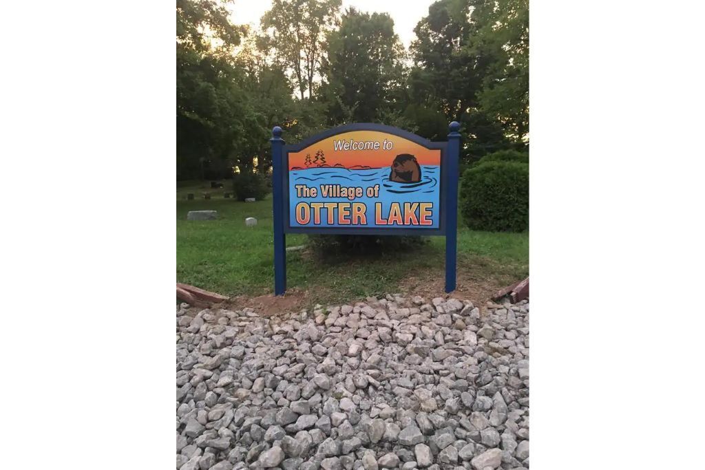 A welcome sign for The Village of Otter Lake.