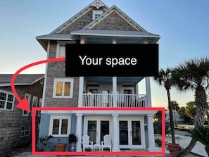 Two-story home with a spacious balcony and covered porch featuring a comfortable seating area.