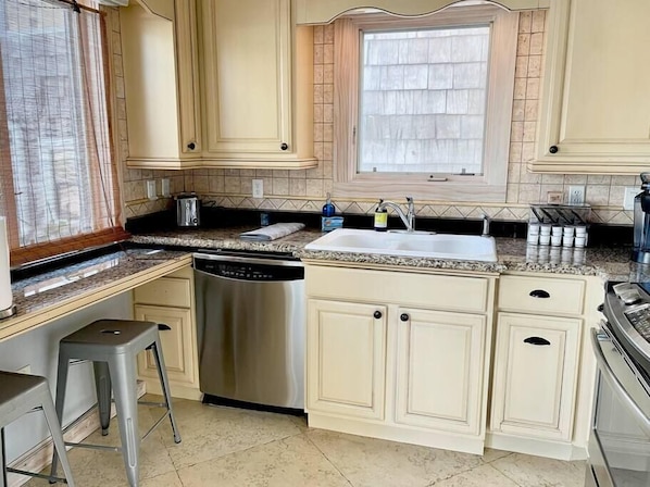 Enjoy cooking in this well-equipped kitchen with a stainless steel dishwasher, modern faucet, and ample cabinetry.