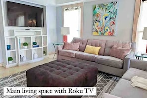 Relax and unwind in this inviting living space with a large flat-screen TV and comfortable sofa.