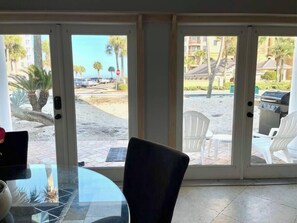 Enjoy a room with a glass table and chairs, sliding door to a patio with barbecue grill and outdoor seating.