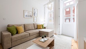 Ein modernes Wohnzimmer mit einer Eckcouch, einem Couchtisch und einer Tür zu einem Balkon.