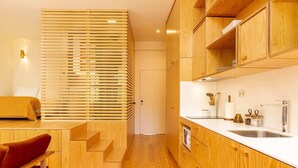 Una cucina moderna con mobili in legno, forno a microonde integrato e lavello in acciaio inossidabile.