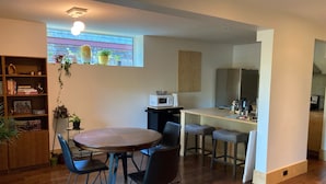 Un espacio habitable compacto con comedor, cocina y una pequeña zona de bar.