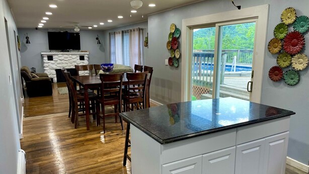 A modern kitchen with a central island, wooden dining table, and chairs.