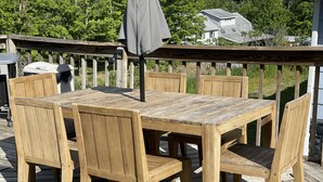 A wooden deck with a table and chairs, surrounded by a wooden railing.